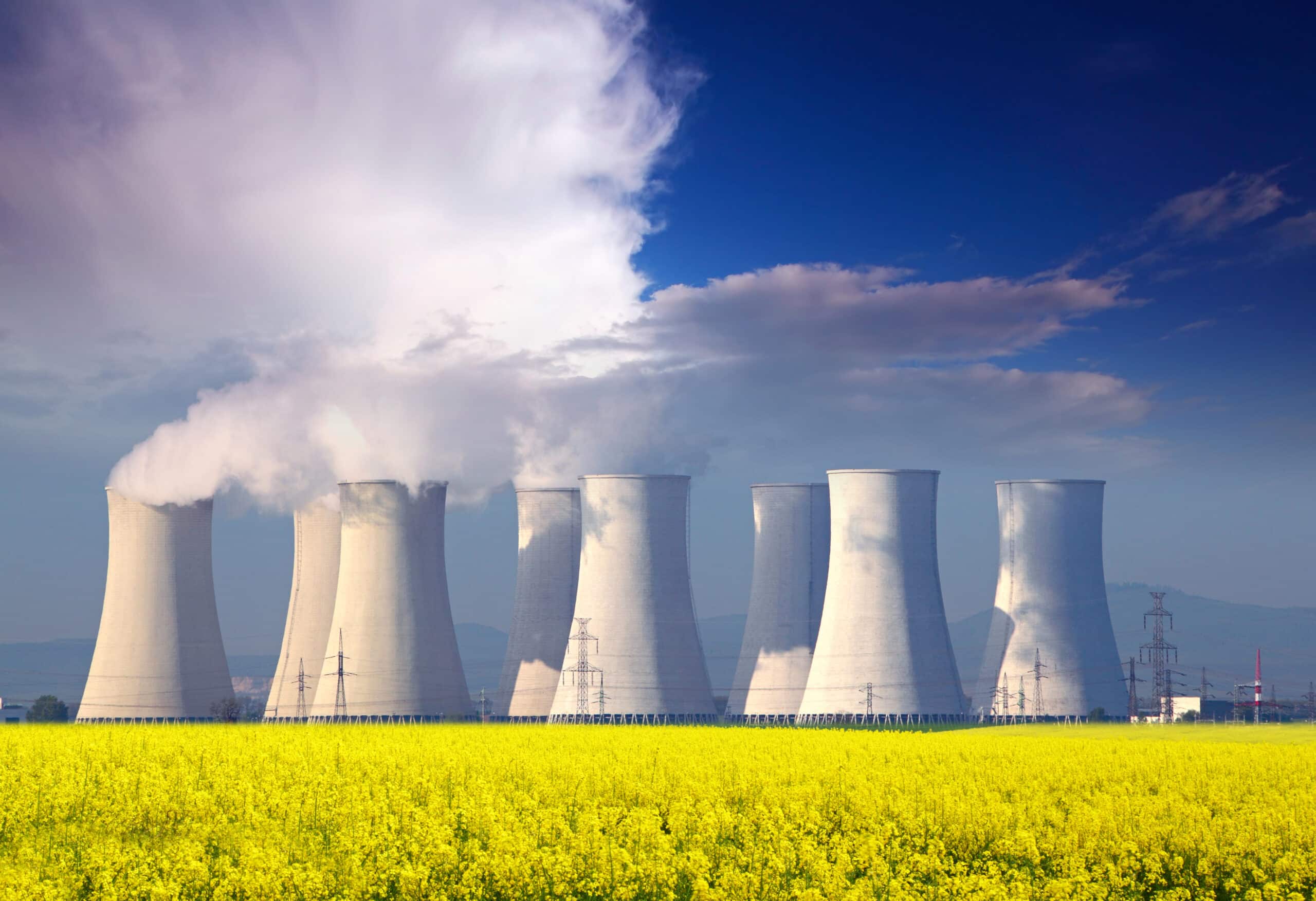 Nuclear power plant with yellow field and big blue clouds.