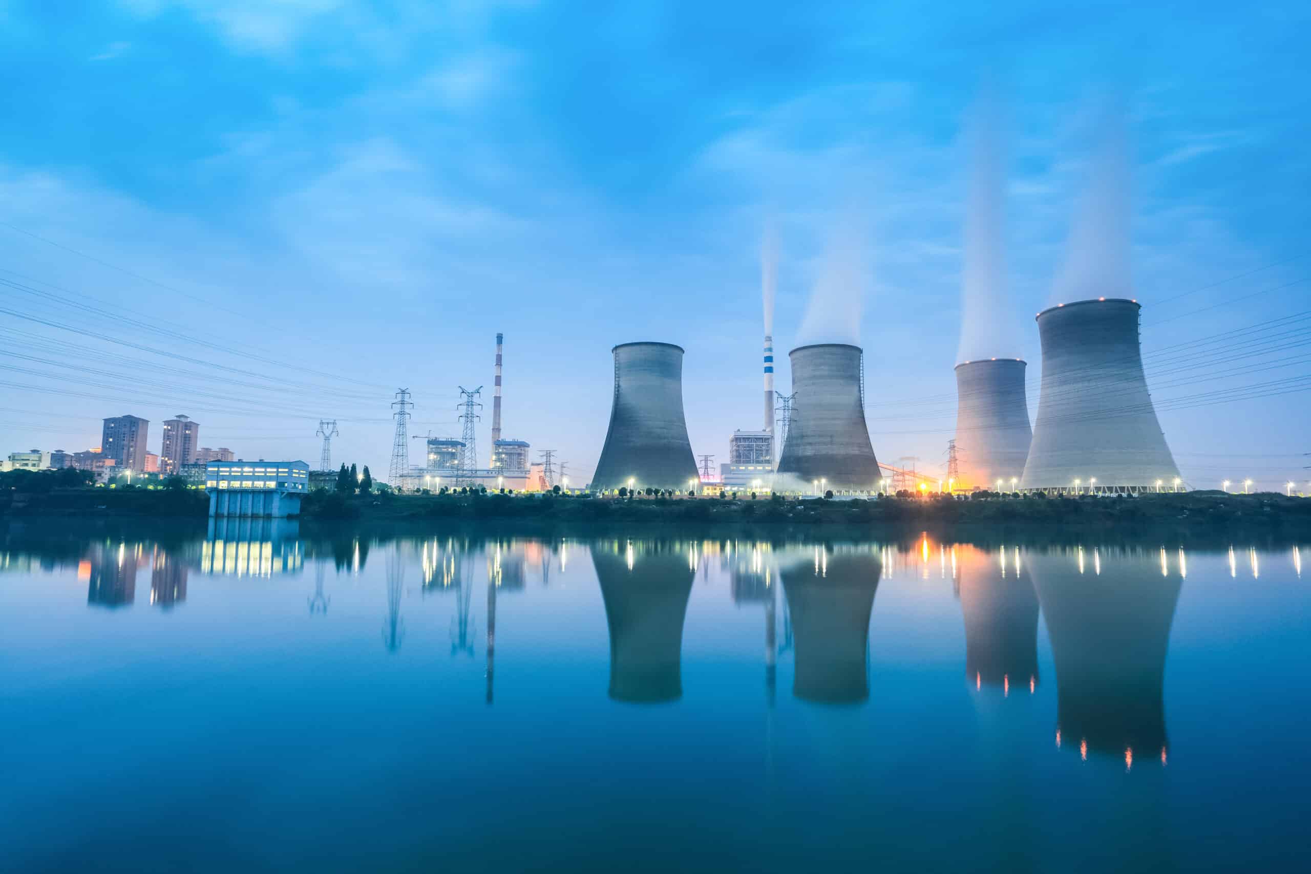 thermal power plant in nightfall ,cooling towers and reflection in the river